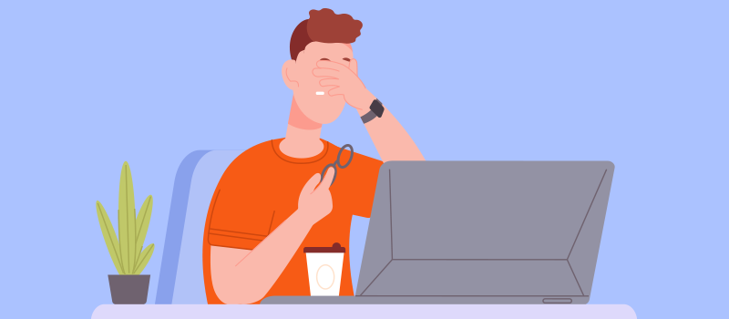 cartoon man sitting at desk with laptop rubbing eyes